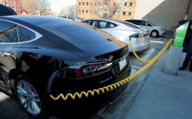 A black car is plugged in and charging at the unveiling of UC’s first electric vehicle charging station near Wherry Hall on the medical campus. Additional stations are planned for West Campus.