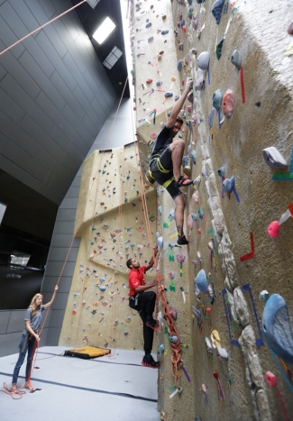 A couple of guys try their hands (and feet) on the 40-foot climbing wall at the University of Cincinnati's Campus Recreation Center