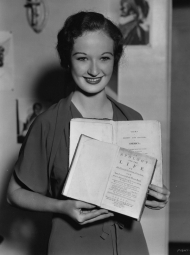 Early in her movie career, Venable holds two books.