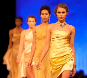 four student models lined up marching down the runway