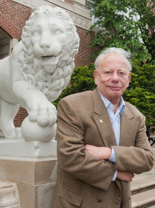 Sigmund Rolat on campus in front of one of the stone lions.