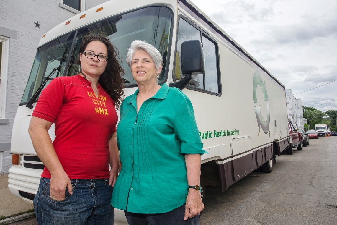Libby Harrison and Dr. Judith Feinberg stand in front of the mobile needle exchange RV.
