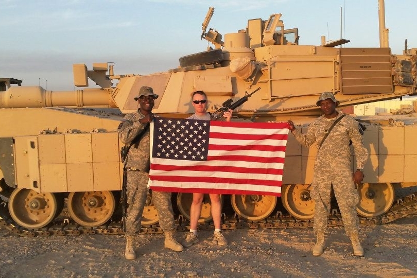 Terence Harrison and other soldiers pose in front of a tank in Iraq.