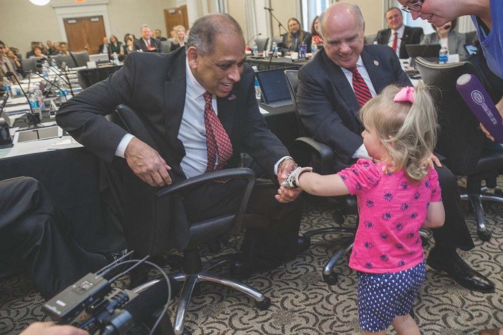 UC President Neville Pinto shakes hands with 3-year-old Ella Morton