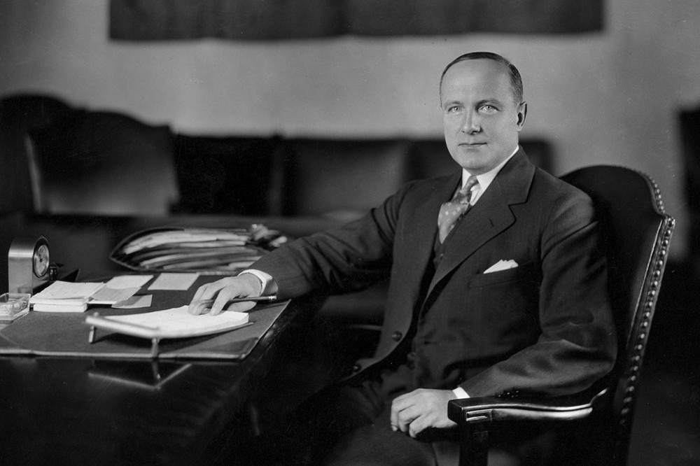 University of Cincinnati's longest serving president, Raymond Walters, a distinguished looking gentleman, sits at his desk.