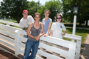 A group of four students pose next to a white four-rail fence at the UC Center for Field Studies.