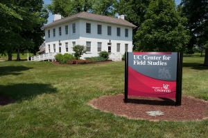 historic Shaker farmhouse sits behind UC Center for Field Studies sign.