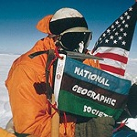 Mountaineer Barry Bishop pins a flag on the top of Mt. Everest.