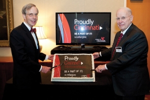 Campaign co-chairs Buck Niehoff and Otto Budig hold up a cake to celebrate hitting the billion dollar milestone.