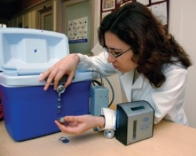 Environmental health scientist Yulia Iossifova calibrates an air-sampling device used to collect fungal spores. Her research reveals that exposing infants to certain fungi may protect them against future allergies.