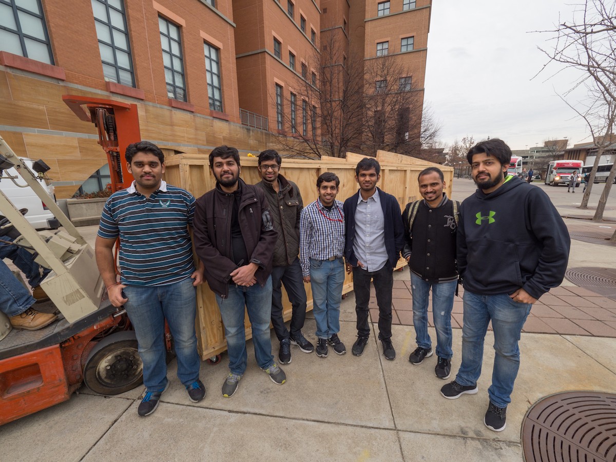 Hyperloop UC teams members pose with their crated prototype in front of the Engineering Research Center.