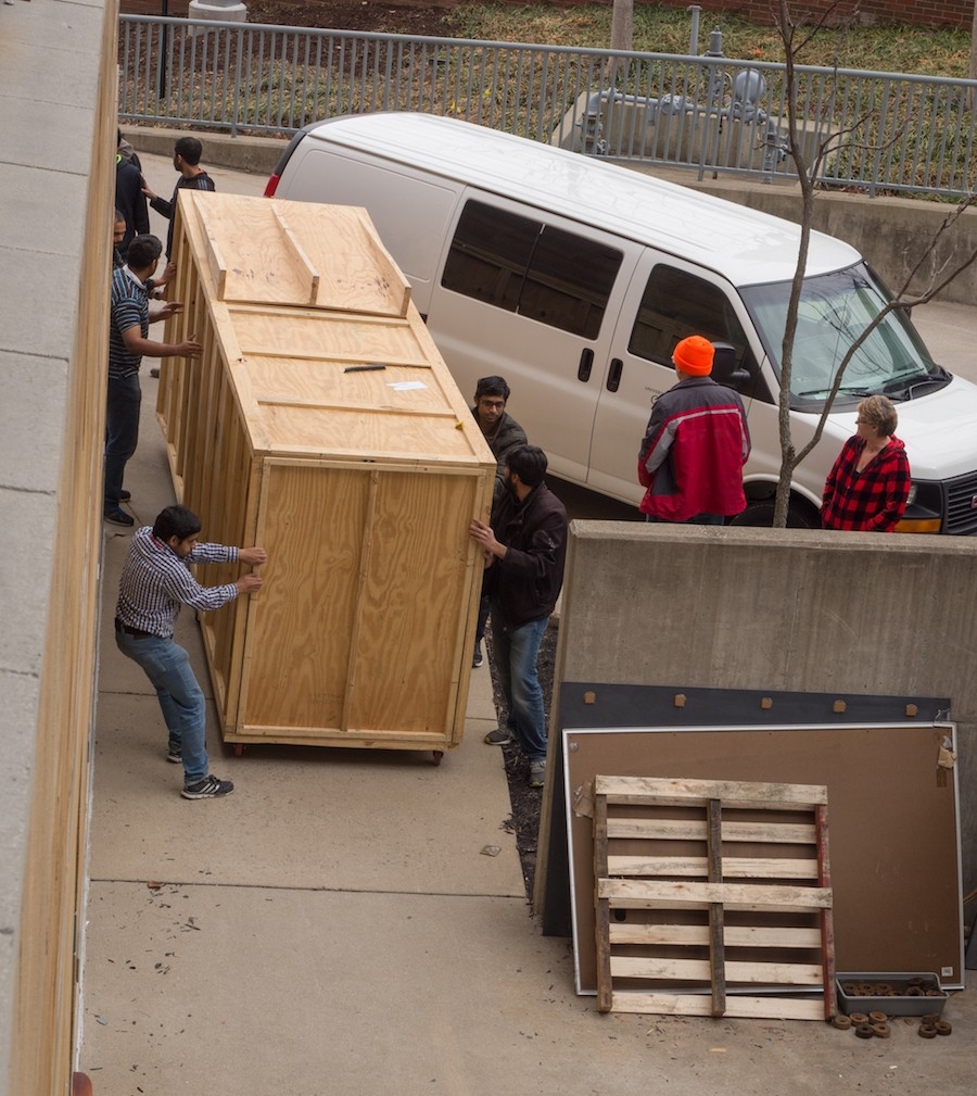 Team members maneuver the prototype toward the dock to ship.